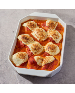 Six stuffed shells in red sauce, served in a white speckled stoneware casserole dish