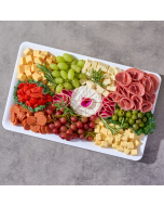 A close-up top view of a cheese tray with brie, grapes, strawberries, and wine cheese spread