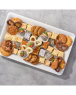 Overhead view of various sweets arranged in a black plastic serving tray.  Including chocolate covered pretzels, miniature brownies, miniature lemon bars, chocolate covered strawberries, and sugar cookies