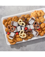 Overhead view of various sweets arranged in a black plastic serving tray.  Including chocolate covered pretzels, miniature brownies, chocolate chip cookies, peanut butter cookies, oatmeal cookies, and sugar cookies