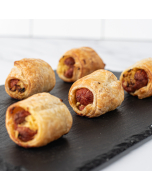 Miniature Coney Island Franks, beef franks wrapped in puff pastry on a wooden board