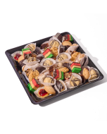 Overhead view of miniature cannoli, miniature éclairs, pistachio glazed cream puffs, miniature sfogliatelle, ricotta cheesecake tart, pignoli cookies, chocolate-dipped Amaretti cookies, arranged in rows on a stone platter