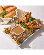 Overhead view of sandwich rolls stuffed with porchetta, roasted red peppers, and broccoli rabe, served on a wooden platter